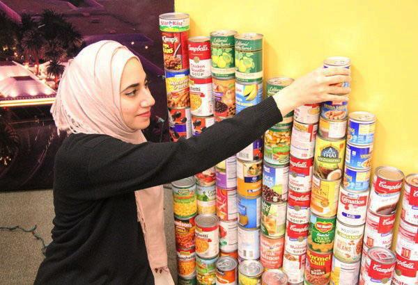 Columnist Summer Thomad re-organizes cans donated by students to contribute to the less-fortunate for the holiday season. Donating non-perishable food items is a great way to show kindness to the less fortunate or those in need.
 Photo Credit: Alex Nedelcu