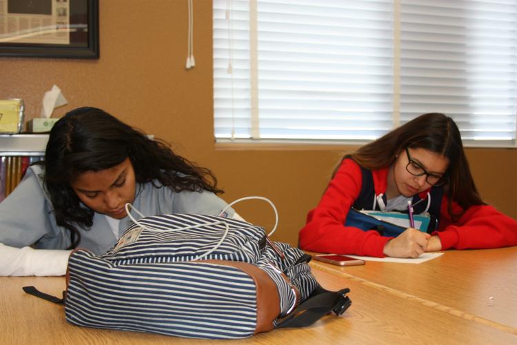 Writing as fast as they can to get the words written down are sophomores Monica Ortiz and Elisa Bustamante. This assignment consisted of writing a phone callers words down in a limited amount of time.