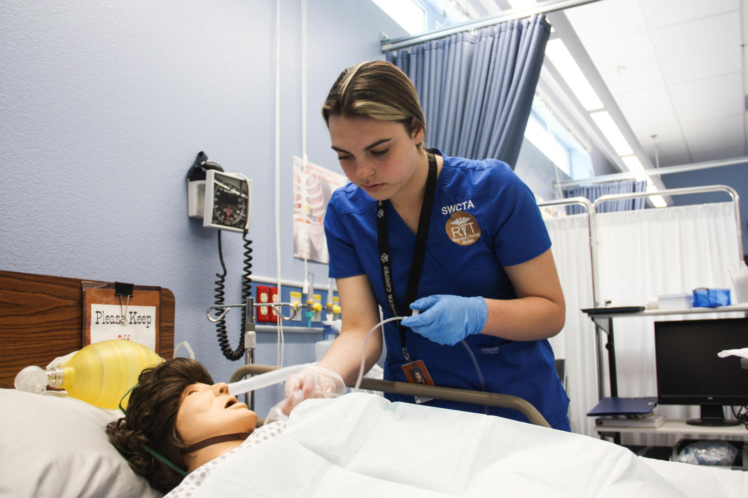 Junior Emily Giblin inserts a suctioning tube in the mannequin patient’s mouth. GIblin had to confirm with Respiratory Science teacher Vicki Smith that she was correctly helping the patient. “I have practiced suctioning, charting, and the basics of tracheotomy care many times,” Giblin said. “Now I feel I have it seared in my head.”