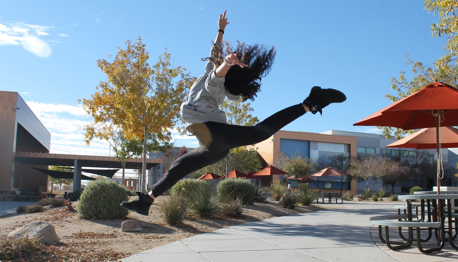 Practicing around campus, senior Kennedy Nelson shows off one of her moves to express herself. “A few photography students asked me to help them with a few motion photos so I did a few jumps and I attempted a leap,” Nelson said. Photo Credit: Maya Negash 