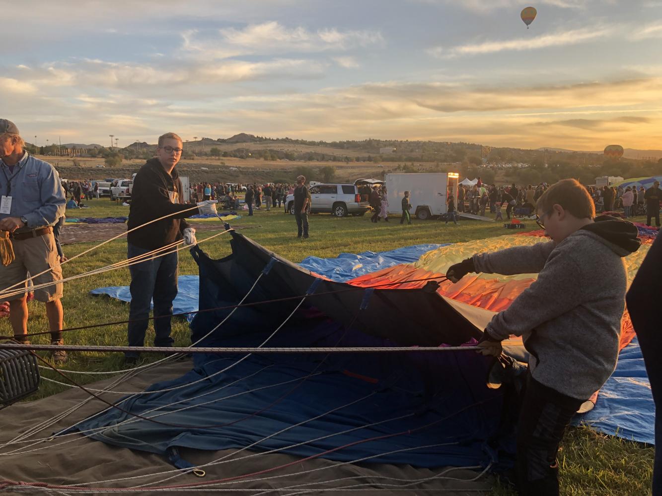 Holding+the+%E2%80%9Cenvelope%E2%80%9D+of+the+balloon+up%2C+sophomore+Landon+Sims+and+his+brother+assemble+their+own+hot-air+balloon+at+sunrise.+Initially+fascinated+by+the+process+it+took+to+assemble+the+hot+air+balloon%2C+Sims+began+to+learn+how+to+fly+in+one.+%E2%80%9CI+got+really+attracted+to+it+when+I+got+to+experience+helping+out%2C+then+getting+to+fly+in+it+as+the+reward+later+on.%E2%80%9D+%28Photo+Credit%3A+Landon+Sims%29