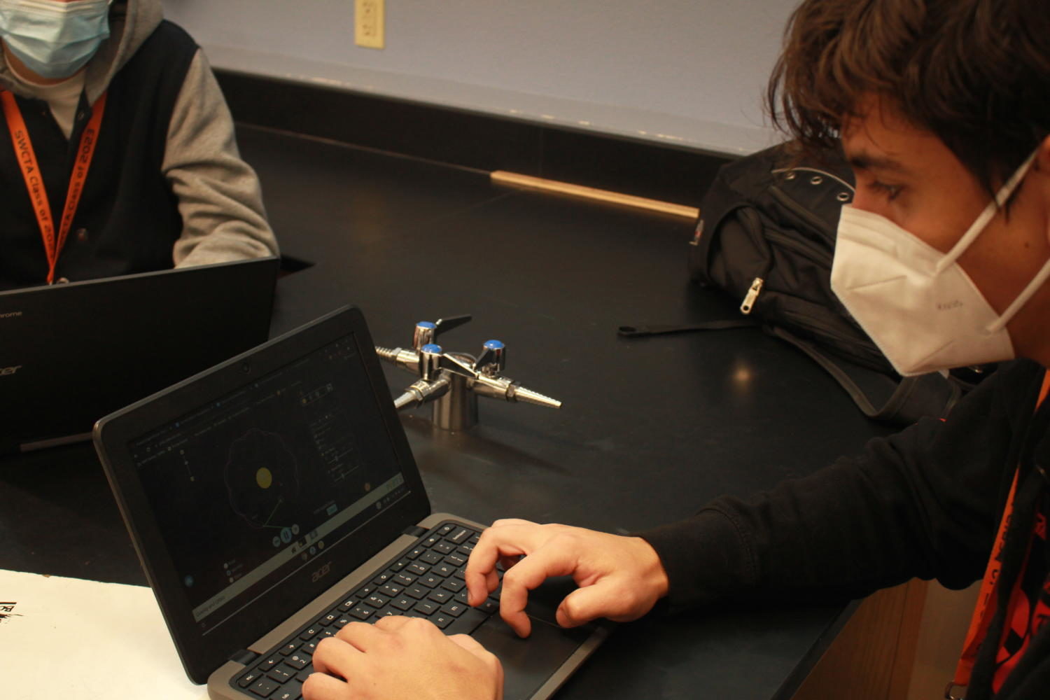 Viewing his lab, junior Andrei Belciug looks at an orbit consisting of Earth, the sun and moon. Students were assigned to edit the mass of the star or planet, view the orbit and record their findings. ¨If I didn’t do the lab, the test may have really negatively affected my grade,¨ Belciug said. 
Photo Credit:Lucas Grubb