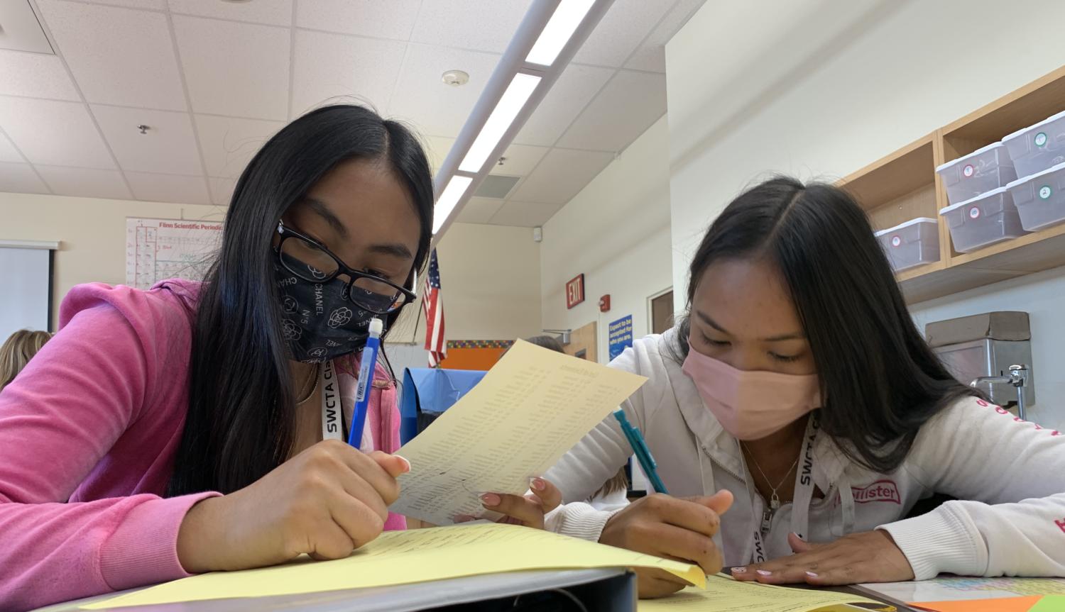 Hard at work, sophomores Angelynne Tiangco and Kelliya Kedora help each other finish their assignment. Students collaborated together during their Chemistry Honors class to complete their ionic compounds worksheet. “I’m very happy to say that my grades are doing very well this quarter and I hope that it stays like that for the rest of my years in school,” Tiangco said. “I’ve been really bad about keeping myself organized and staying on top of things, that I’ve gotten into the habit of doing things last minute, as well as getting distracted very easily. While I’m doing very well in my classes, the process behind it has been the opposite.”  Photo Credit: Crystalyn Estabillo