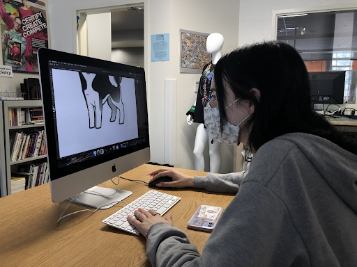 Tracing an image of a wolf to include in her design, senior Mia Nenadic works on her yearbook cover. Students had to include some type of husky mascot as a requirement from the client. “The hardest thing about the project was probably making sure it’s good enough to present to a client,” Nenadic said. “It’s not just between us and Mr. Ball, it’s going to an actual client to eventually be put into print, hopefully.” Photo Credit: Juliana Borruso