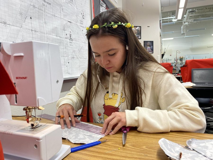 Using her moms old dress, senior Alexandra Ferran finishes a seam. Their completed designs must be done before November 4. “I recently had to change the direction I was going in, but luckily I found this fabric in some old stuff my mom had so I think Ill finish in time,” Ferran said.