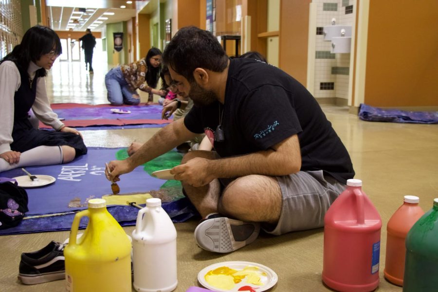 Painting a Prom poster, junior Sahib Rattan draws the landscape around Rapunzel’s castle. About 500 people are expected to attend Prom. “Everyone has really been looking forward to Prom,” Rattan said. “It’s a huge event so we’ve been working really hard for months to plan this.”
