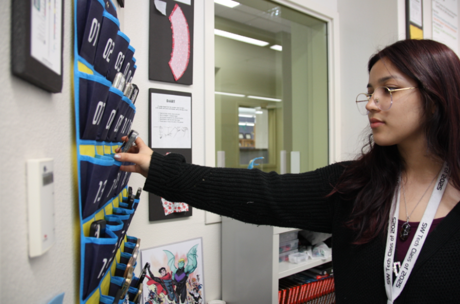 Placing her cellphone into the holder, sophomore Alize Quiroz abides to the new restrictions put in place after a series of fake social media accounts were created with the school’s name. This rule was put into place to limit cyberbullying, mainly through the action of taking pictures or videos of students during school hours. “We were never really allowed to use our phones in class anyways,” Quiroz said. “Implementing this new rule really just enforces the current one. I don’t necessarily think this is the correct solution, because there’s lots of other things that could prevent cyberbullying a lot better because it’s going to happen no matter what. However, I see how admin may think it’s fair.”