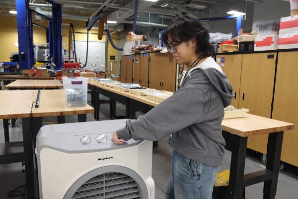 Attempting to cool down an Engineering classroom, senior Brandon Pecayo adjusts a small portable fan. Over the past month, the F building has been one of the places on campus that has been the most affected by the AC breakdowns. “The fan in the room definitely makes it more comfortable to work,” Pecayo said. “I like being able to do my work in comfort instead of having to sit in the heat.” 