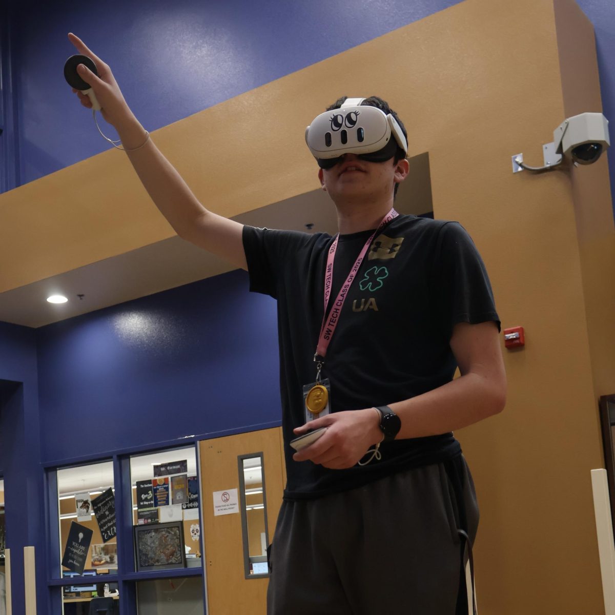 Photo Caption: Before the start of class, sophomore Connor Wiggins assists in setting up virtual reality headsets. Students have been engaging in VR-integrated learning. “We are working to integrate projects we’ve made with Unity, which is the game engine that we use,” Wiggins said. “Once its into virtual reality, you can control every aspect of your 3D world as if it were really there.” 