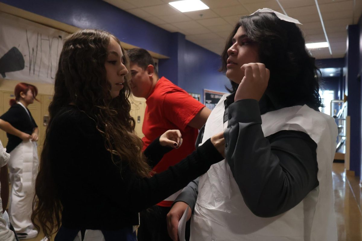 With his friends there to help him get ready, senior Travis McGinnis prepares to be married to Journalism. “It was really thrilling,” McGinnis said. “I was really anxious because they put a veil over me and I couldn't see anything. When they walked me down the aisle, they kept tripping on the chairs, so I was tripping on the chairs. 
