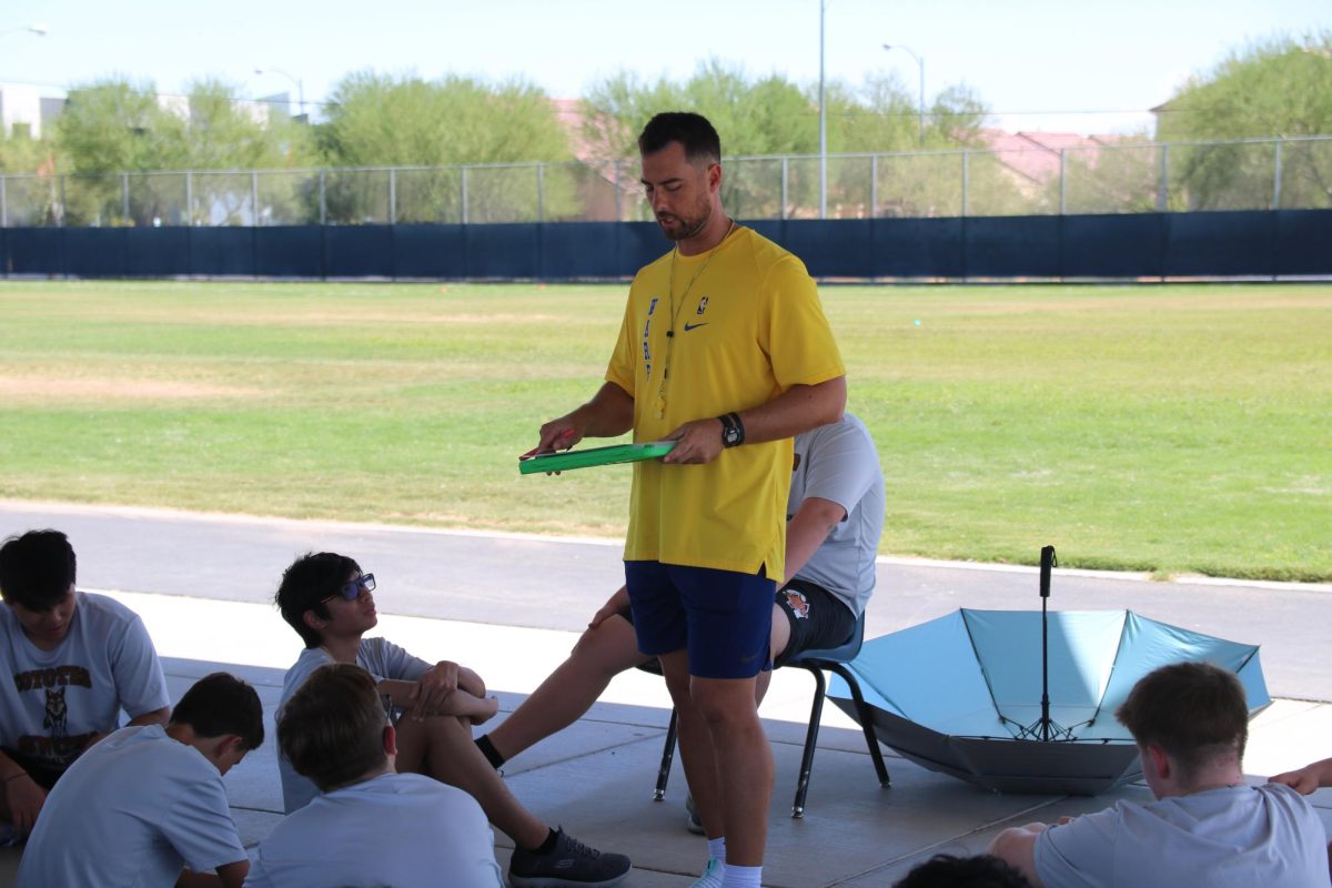 Going over the results of all the matches played during the period, PE coach Mark Bly advises his students on how to do better next time and the plan for next class. They played paddle tennis in this unit. “The boys are loving this unit but it is really hot,” Bly said. “Since the heat isn’t going away I’ll only make them run two laps for the mile.”
