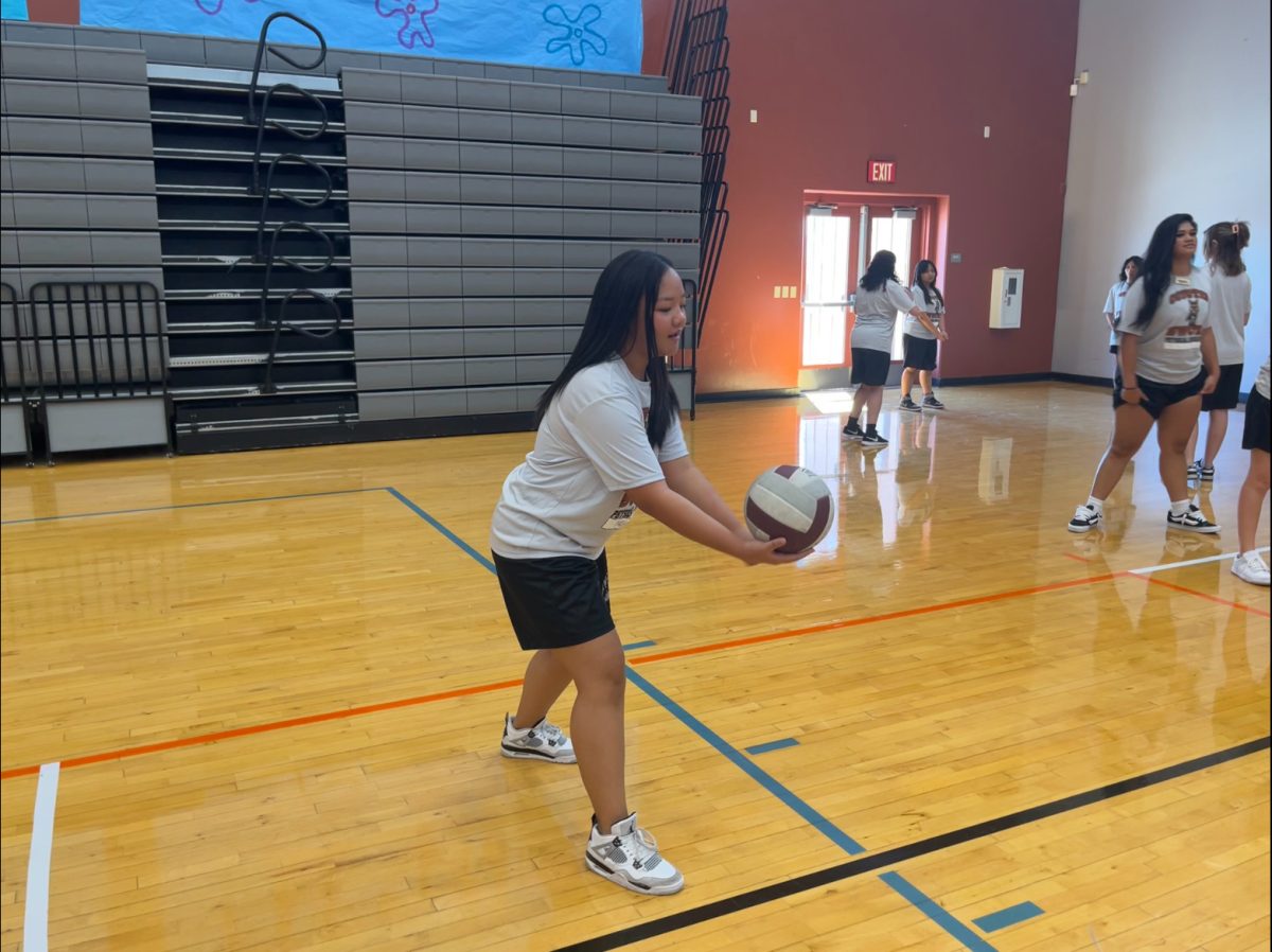 Focusing in at the beginning of the practice match, sophomore Zacharene Maliaman preps to start the play. Prior to the tournament, students practiced serving the ball over the net. “I love volleyball,” Maliaman said. “I’m also really competitive so I’m super excited to start going against everyone else.”