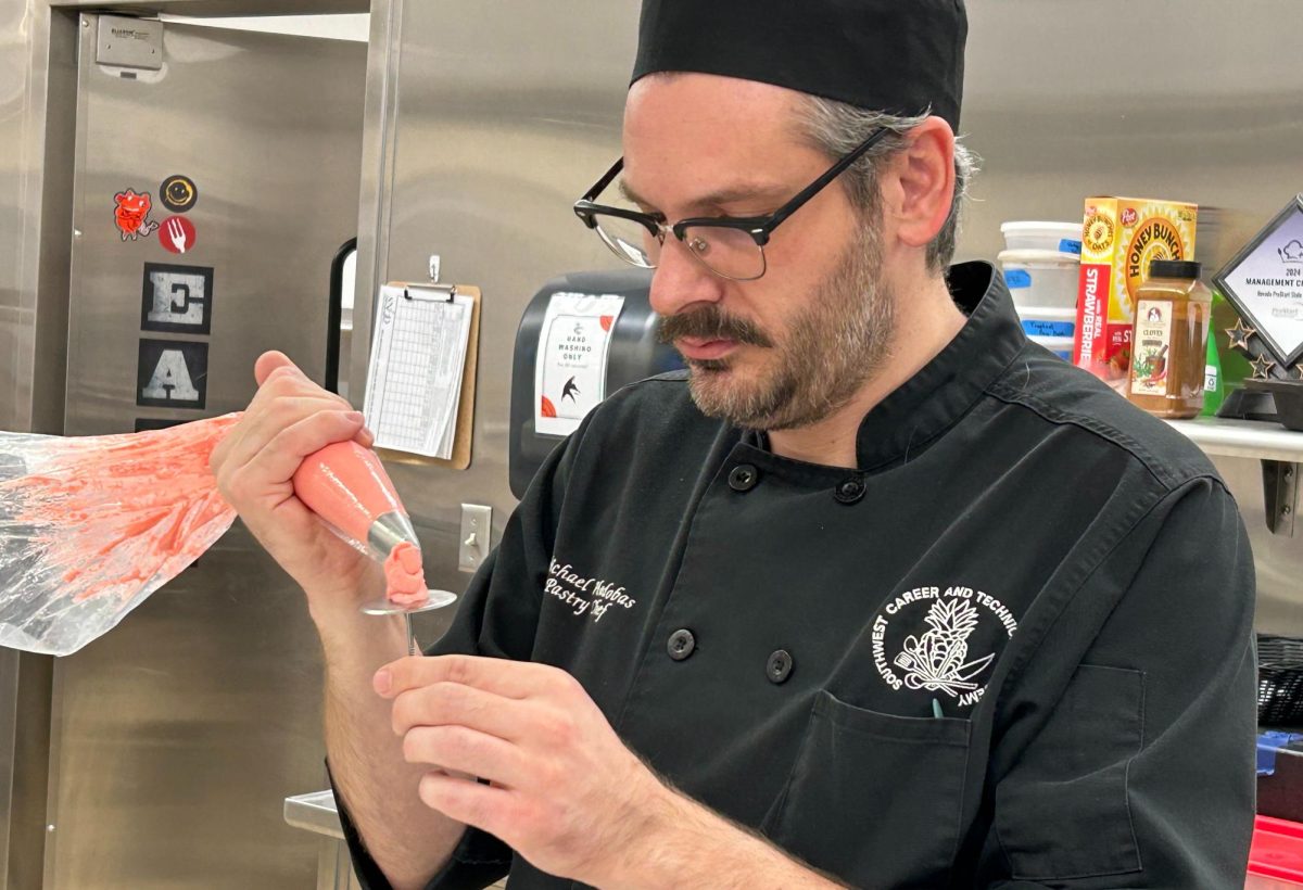 Demonstrating the correct piping technique to his class, Chef Michael Hadobas goes into intricate detail about piping roses. Mastery of this technique made it easier for the students later on in the unit. “Knowing exactly how to hold the piping bag is important because just a couple of degrees off can totally change how the finished product looks,” junior Addison Marsh said. “From Chef, I also learned how to move the nail around so that you weren't making more work for yourself and just letting the nail do the work for you.”