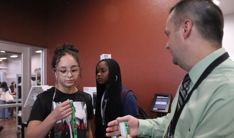 Assistant Principal Cameron Roehm stands outside the cafeteria entrance handing out green temporary IDs to the students who forgot their IDs. This policy revamp was created due to last year's temporary ID weakening security measures causing it to be inefficient. “In the past, we did not see much success with the sticker IDs,” Roehm said. “With the new policy, [administration] is starting to notice a decrease in the sales of temporary IDs.”