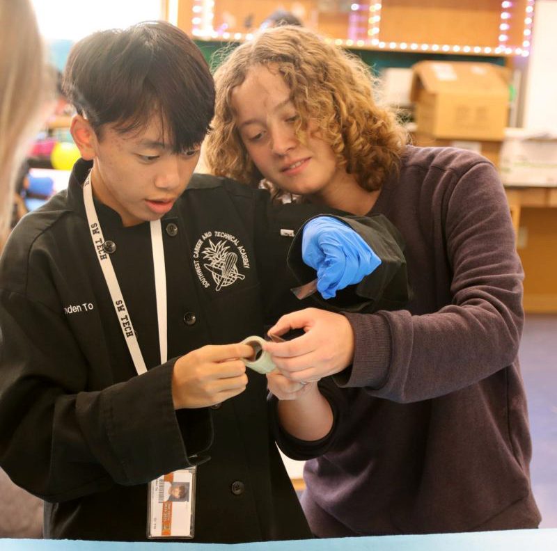 Participating in a fingerprinting activity, senior Roxana Huve assists fellow club member Branden To with applying his own fingerprint to a CD. "I love being able to find and identify fingerprints," Huve said. "It [was] so fun, and looked really nice afterwards."