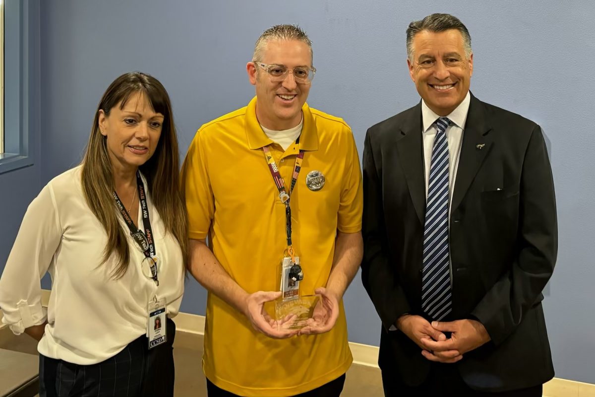  Standing next to Principal Donna Levy and UNR President Brian Sandoval, psychology and US history teacher Benjamin Lacombe showcases his new award. Lacombe received this award while teaching a class to the excitement of his students. “We were giving him a round of applause,” junior Valentina Escobar said. “I really think he deserves it.”