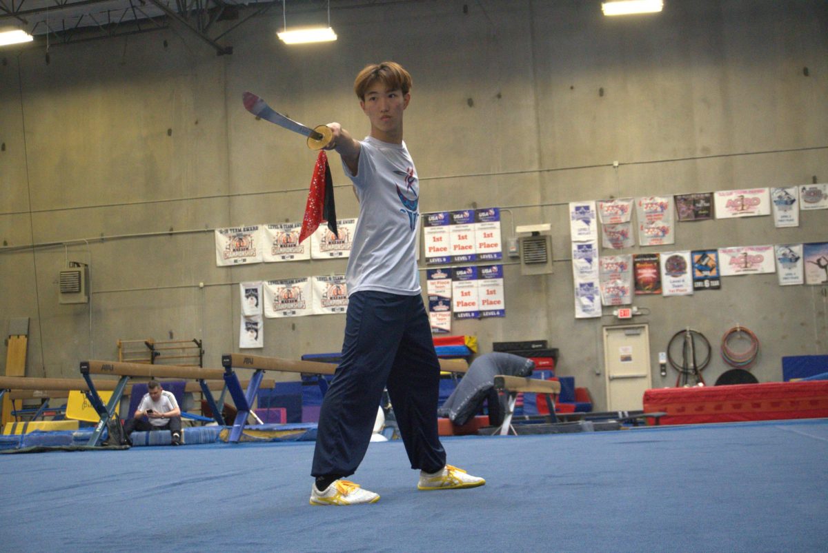 Demonstrating discipline and elegance, junior Ashton Yim warms up before starting his daily wushu practice. Warming up prepared Yim’s body before his real training began.  “You have to think about it as a transitioning phase,” Yim said. “Before warming up, our joints, muscles, and mind are cold which can lead to injuries. Warming up helps the athletes to get prepared for big ranged movements. For my sport, this is especially necessary. Warming up would prevent me from dislocating, tearing, or fracturing bones, muscles, and joints. One small mistake and it could cost you your career. No muscle or joint can adjust into a heavily dynamic movement after you’ve sat down for seven hours of schooling.”