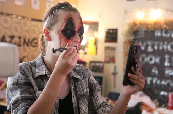 Preparing to scare people at the Trunk or Treat haunted house, senior Breeana Rodriguez dresses up as an acrobat. She was inside the haunted house throughout the whole event. “Hearing people scream is hilarious,” Rodriguez said. “I made sure to make my look as realistic as possible to scare people.”