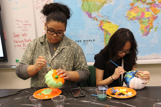 Painting their pumpkins during FCCLA’s annual pumpkin painting meeting, juniors Aki Javier and Rizzael Maniego work alongside each other. The members were able to choose their own designs when decorating their pumpkins. “I wanted to win the best pumpkin [award],” Maniego said. “I tried painting Starry Night by Vincent Van Gogh and I feel that it turned out pretty good despite the short amount of time we were given.”