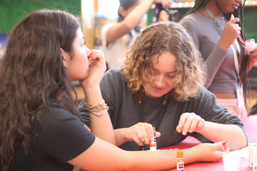 Creating a fake wound, senior Roxana Huve uses various supplies to make the injury as realistic as possible. Members participated in hands-on activities to gain in-depth understanding of the focus of the meeting. “I was applying a glue stick onto Emily’s arm and adding toilet paper onto it to create a realistic wound,” Huve said. “It was a fun activity and we got to learn about wounds and how they’re inflicted.”
Photo Credit: Allee Lin