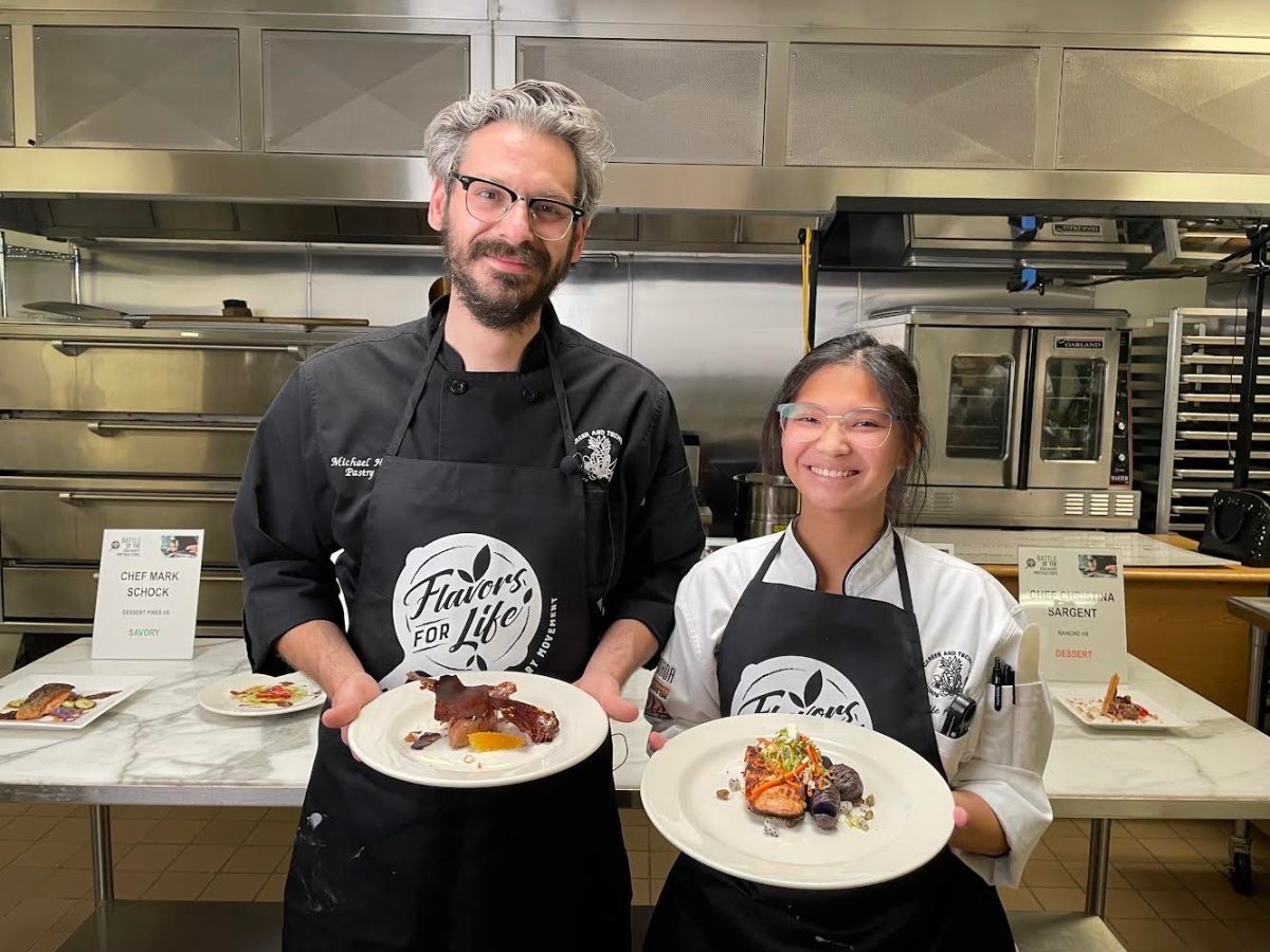 Posing with his student, Michael Hadobas and Razelle Antipuesto branch out their plates they submitted for their contest. The two had competed in the competition “Flavors For Life,” where high schools compete against each other to make a dish from a mystery basket of ingredients. “It was very fun,” Hadobas said. “I felt quite proud to win!”