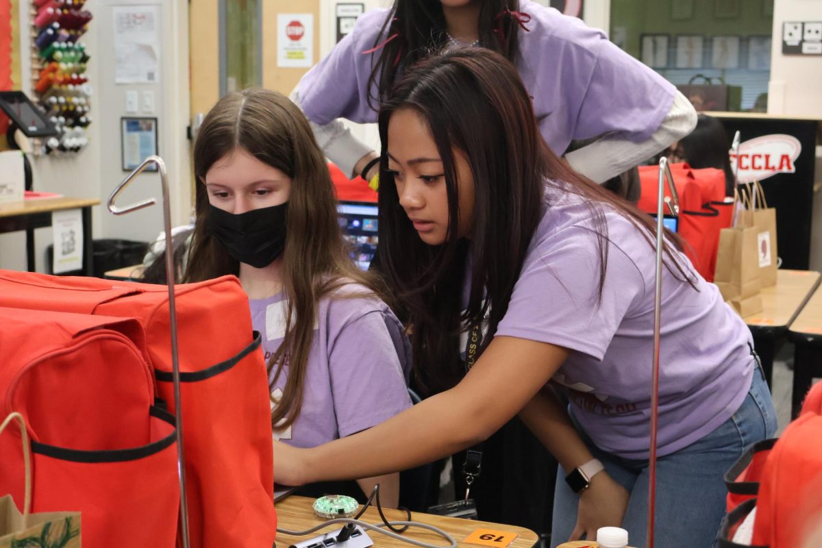 Volunteers help a middle schooler with an LED programming activity. Girls In Tech offers four different specialized areas such as this where students combine creativity and technical knowledge to make a finished project. “I love the light bulb moments,” Girls In Tech Coordinator Dana Cuni said. “Like the first time the kids make a siren turn on in their circuit playground and their eyes brighten up and they get excited and they cheer. It’s why I do this.”
