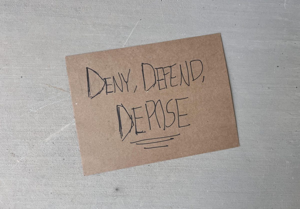 A sign depicting the words “deny, defend, depose,” referring to the slogan many healthcare insurance critics use in protest. This phrase mirrors the common healthcare tactic known as “delay, deny, defend,” where providers will deny claims in hopes for increased profit margins.