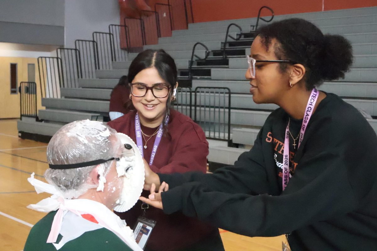 Working with a friend, junior Joanna Mengistu pies one of her teachers at last year’s Pie-A-Palooza event. All proceeds raised last year went to fund prom. “My experience at last year’s Pie-A-Palooza was amazing,” Mengistu said. “It was such a fun experience and I could clearly see that it brought students, teachers, and staff together in great ways.”