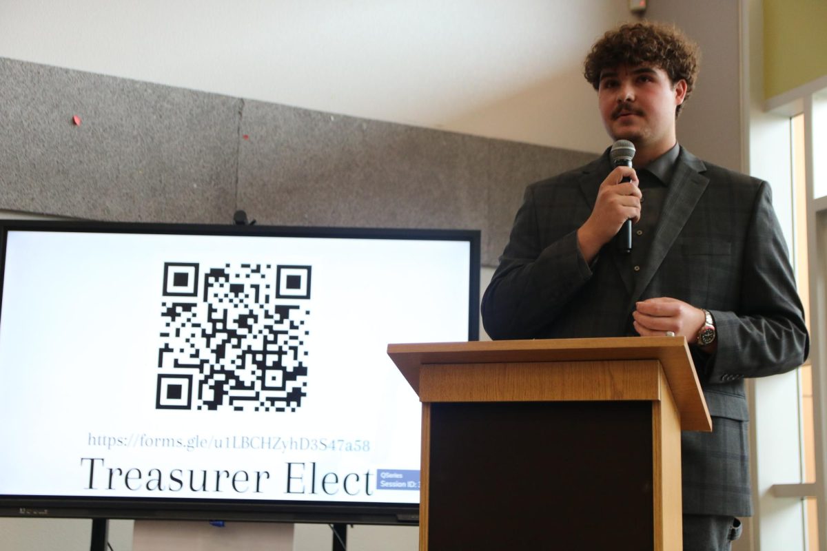 Responding to a question on stage, senior Preston Schwartz tells club members why he would make a suitable candidate for a board member. National Honor Society voted on their board members for the 2026 school year. 
