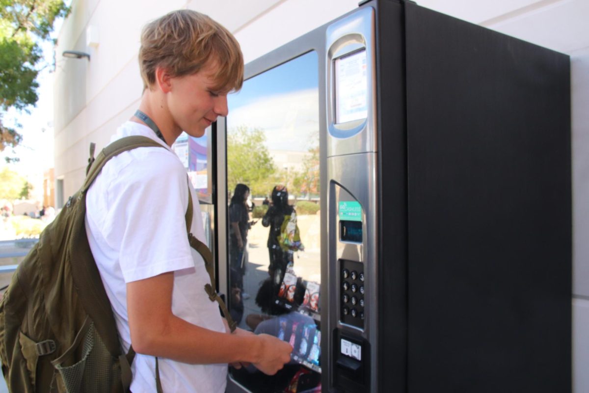 During lunch, freshman Austin Nowak buys a snack from the vending machine. Since the re-adoption of the CCSD guidelines, the vending machines have been restocked with healthier food options. “[The guidelines don’t] really affect me but it could affect different people,” Nowak said. “It’s all about opinions.”