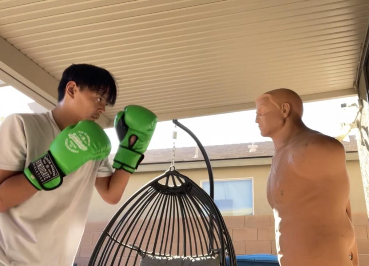 Squaring up to a practice dummy, sophomore Cypher Andres prepares to throw a punch. Dummies are regularly used to help him prepare certain hits to take his opponents down. “[Boxing dummies help me practice] because it’s basically a model of the body,” Andres said. “It helps with accuracy, such as pressure points behind the ear, and a clean liver shot can end the fight.”