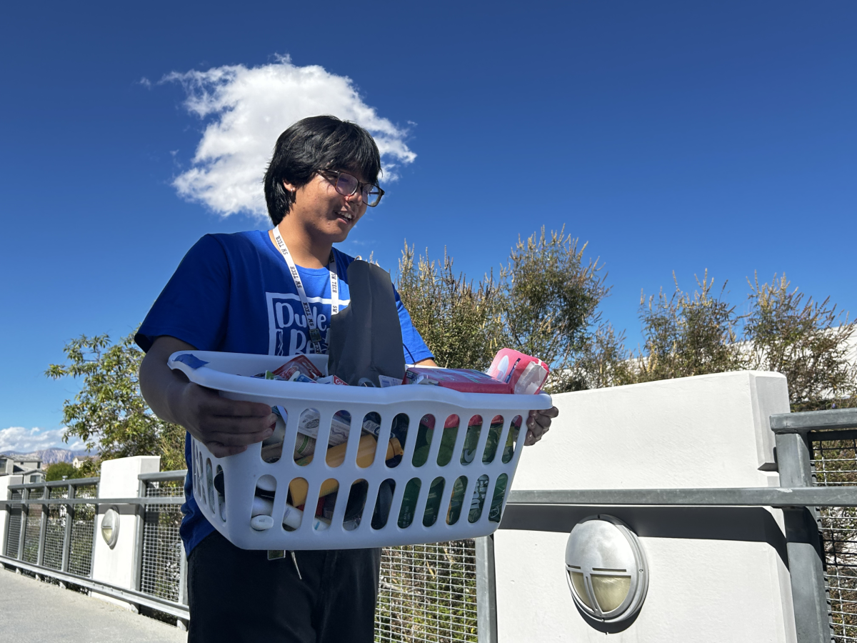 Returning to class, junior Aldrich Gabriel Razon carries a basket of donations back to Student Council Adviser Michael Woxland’s classroom for the Caring Closet Drive. Earlier that morning, Razon helped collect clothing and hygiene items from the library to be sorted before distributing them to Faiss Middle School students. Razon said. “It was special because these items were being donated to students in need to help contribute to their success in school.”