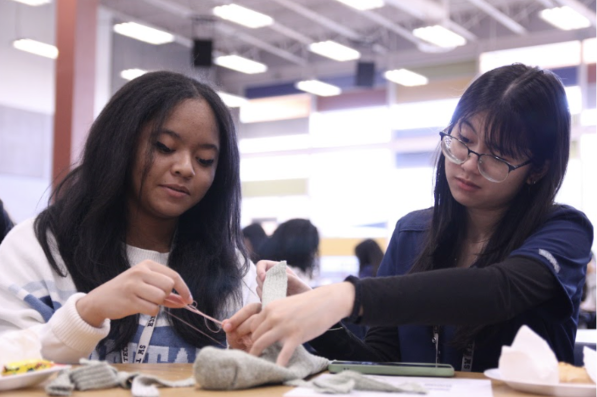 Making a sock puppet, juniors Mya Primitivo and Emily Pinili participate in HOSA’s sock monkey service activity. “I feel like volunteering activities like this is really helpful in connecting students with things outside of school,” HOSA President Elect Aldritch Razon said. “I think students doing something for people outside of school can help bring a sense of togetherness to a community.”