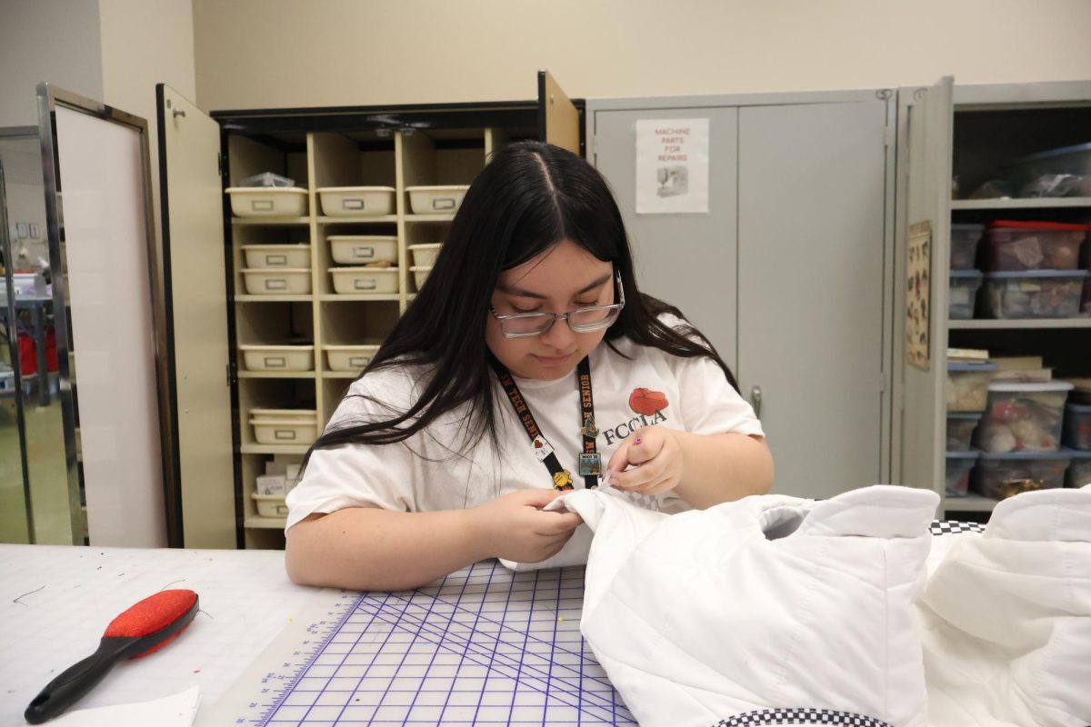 Working on a garment, senior Valentina Escobar adds ribbon trim to a train of a jacket. The project was meant for the Formula 1 fashion competition. “What I really love about FCCLA is the fact that I get to work within my program area, which is fashion,” Escobar said. “Fashion is my passion and it’s genuinely something I want to do after high school, so FCCLA has allowed me to develop my technical skills and become more creative.”
