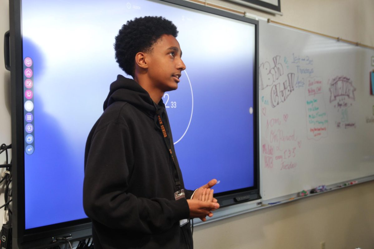Presenting his topic, senior Simon Asfaw summarizes the facts and information from his research paper. Students in English 102 had two minutes to recap their topics. “It's okay to say, ‘um,’ and ‘uh,’ it’s not like a formal presentation,” English 102 teacher Amy Lutz said. “You get to take a little pride in what you've worked on for over a month of time and I think that is a good thing.”